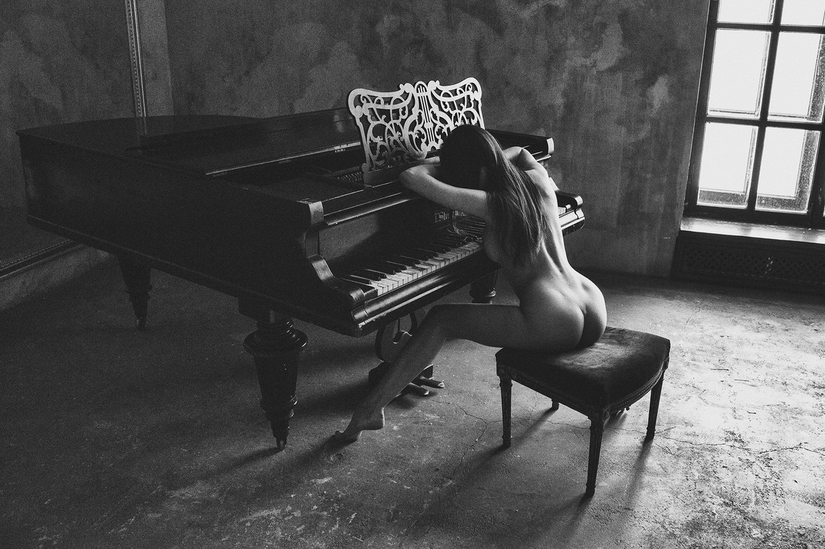 A girl sleeping on a piano